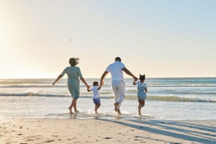家族が浜辺を歩いているイメージ画像