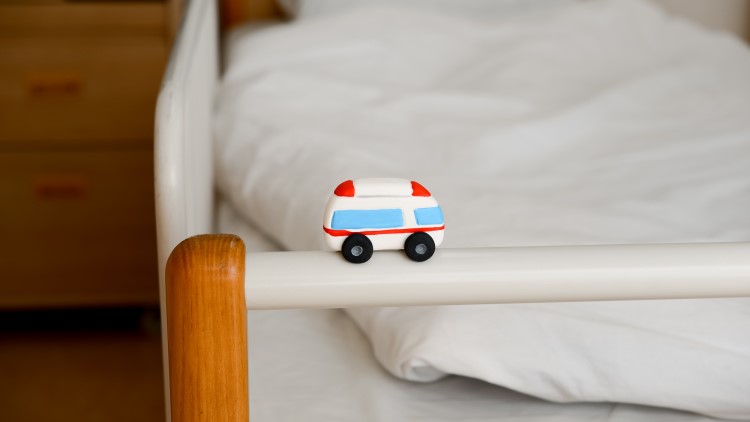 病院のベッドに乗ったミニチュアの救急車