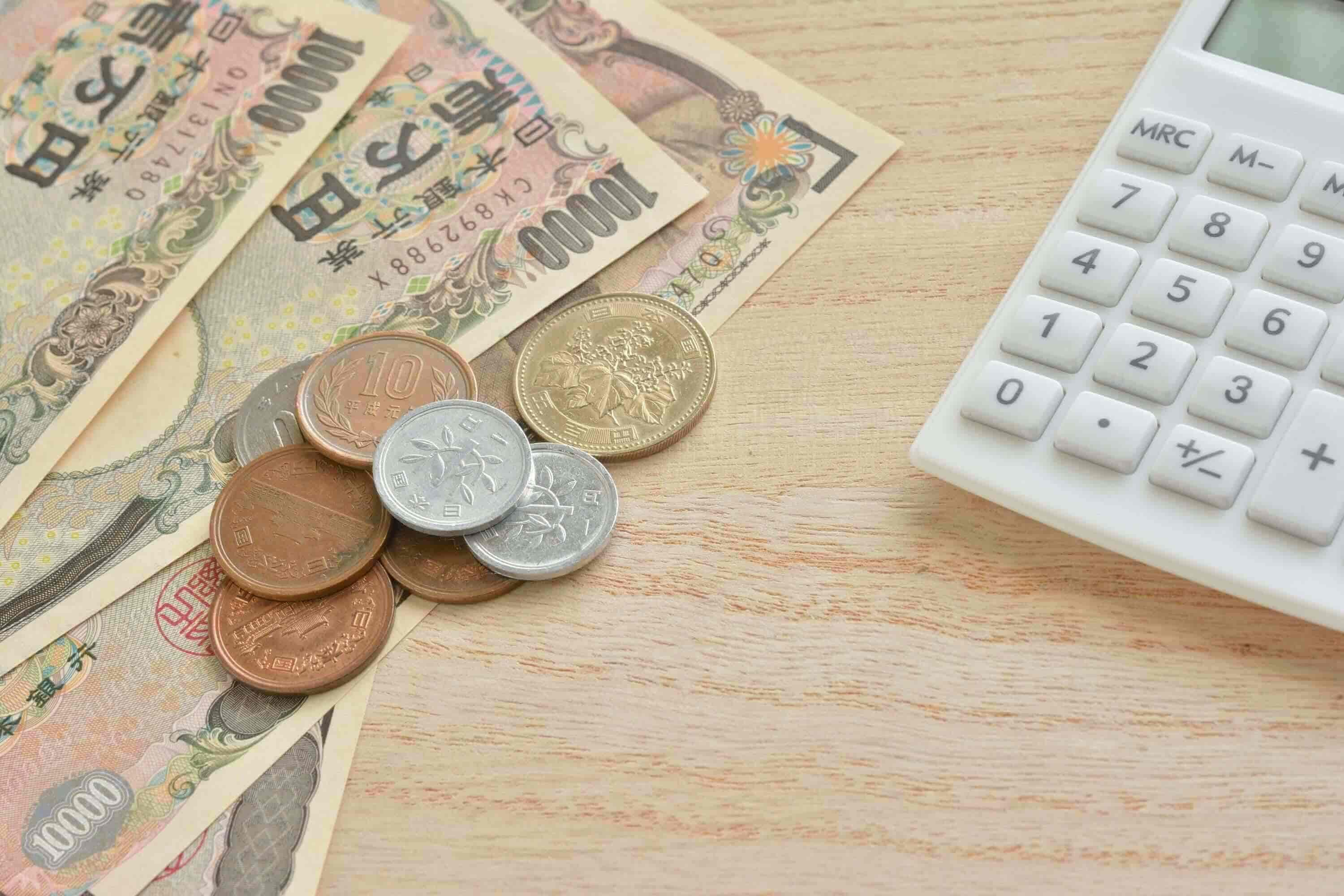 電卓と現金の画像