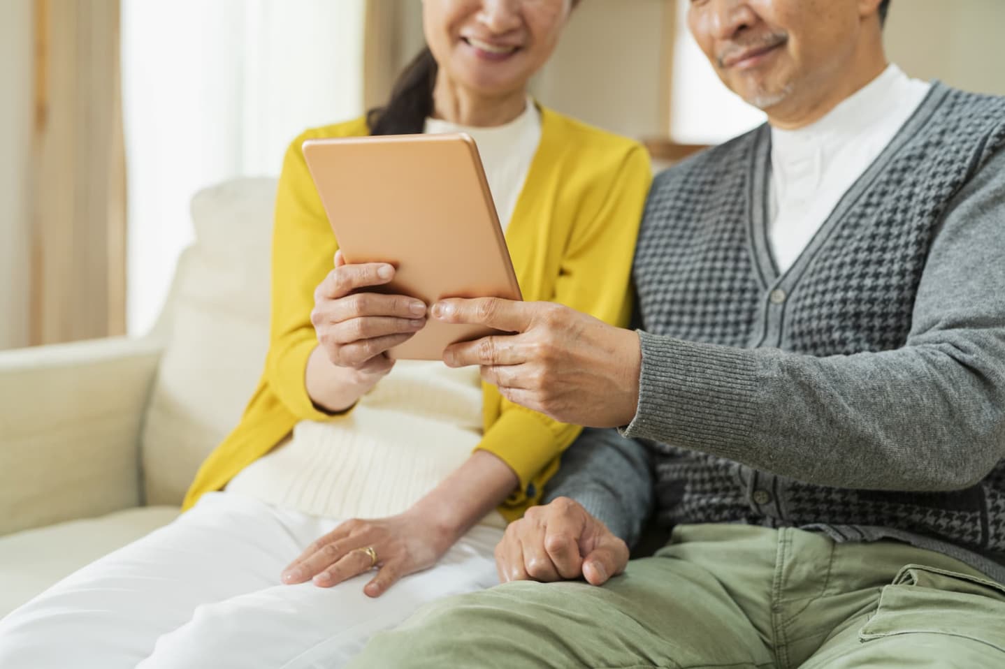 タブレットを見る夫婦のイメージ画像