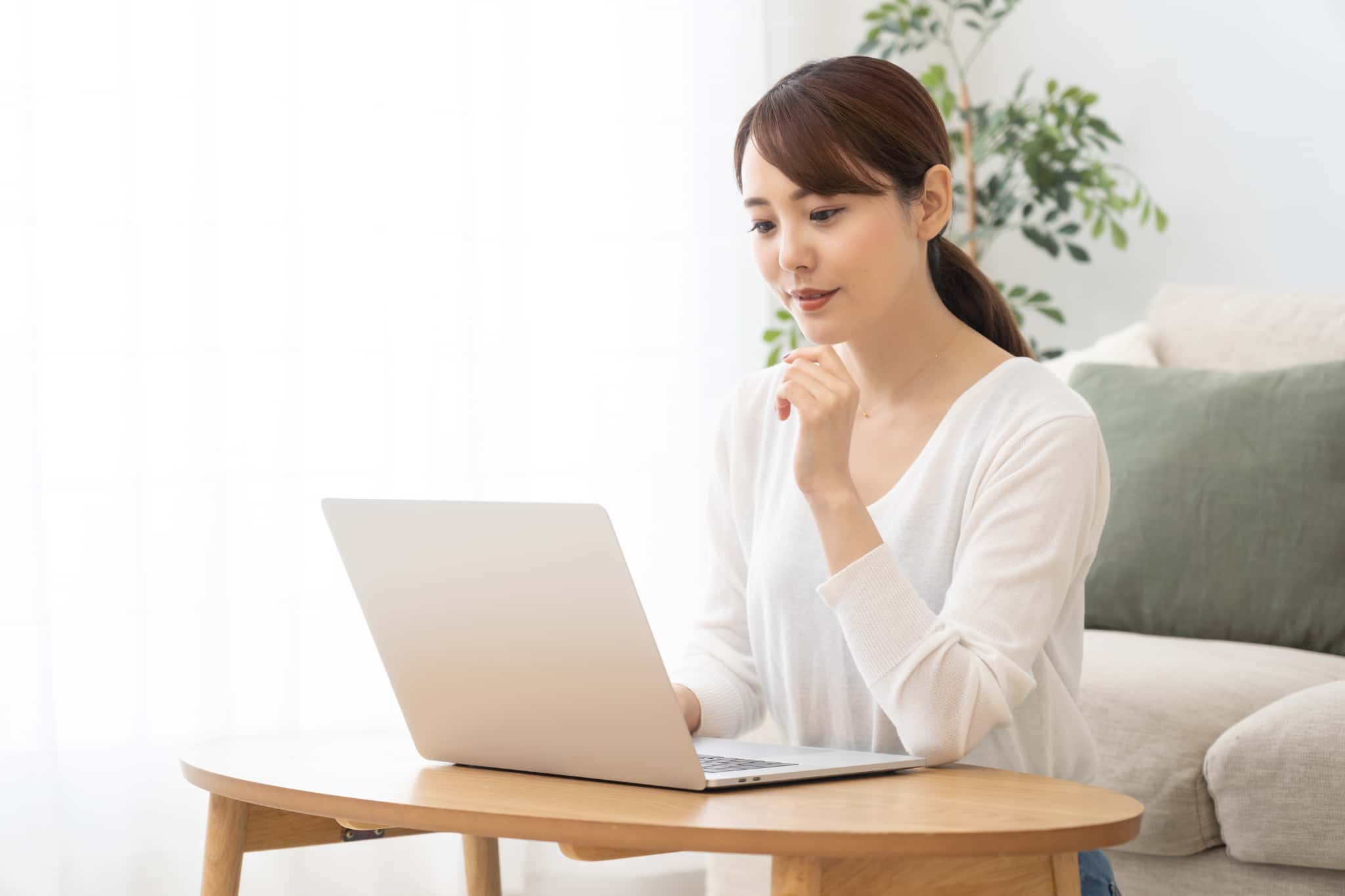 PCの前で悩む女性