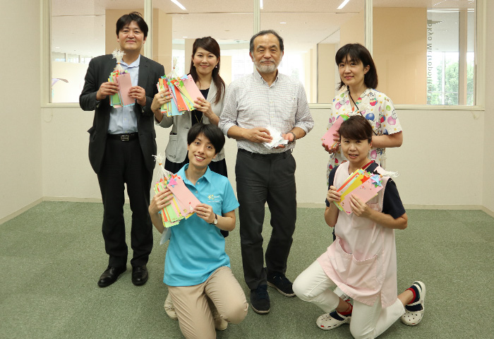 東京都立小児総合医療センターの田中副院長と保育士の皆さん NPO法人シャイン・オン・キッズ村田さん(写真左下)当社チーフ・マーケティング・プロポジション・オフィサーの野口(写真左上)